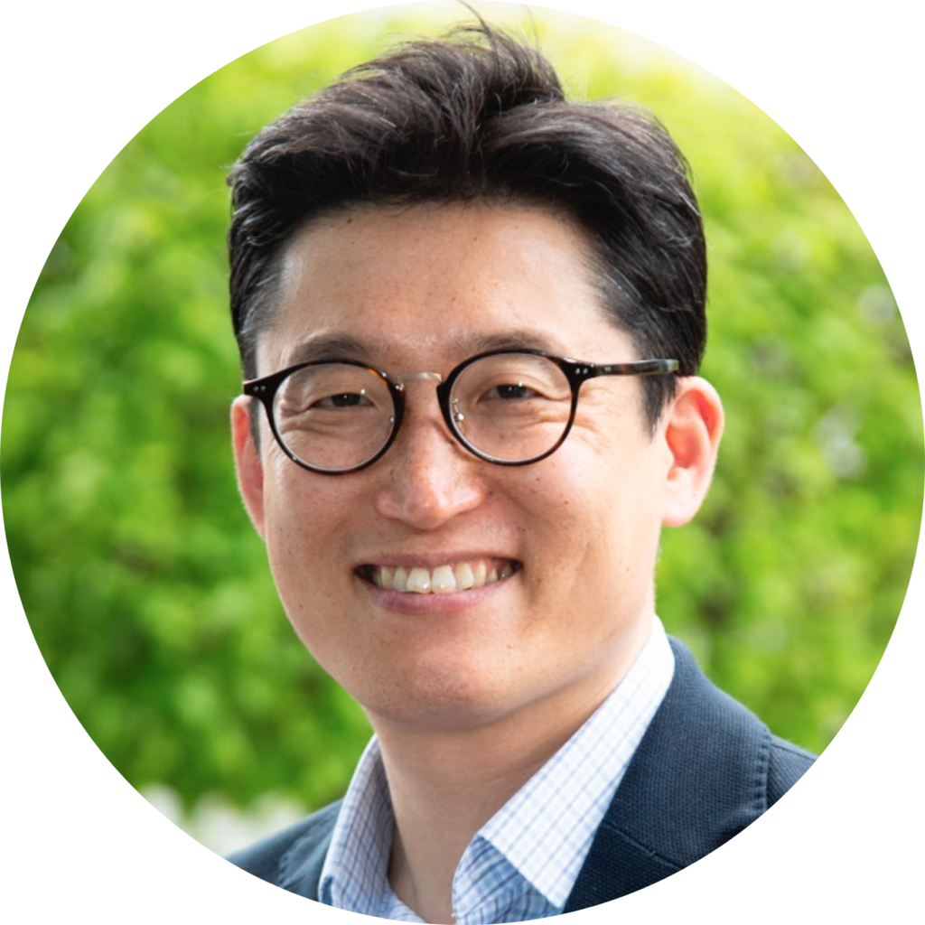 Namshik Han smiling wearing a blue shirt and suit jacket